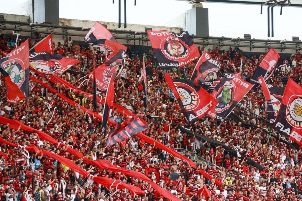 Flamengo leva a semifinal para casa com missão de transformar controle em perigo Torcida do Flamengo agita bandeiras nas arquibancadas do Maracanã, no Rio de Janeiro.